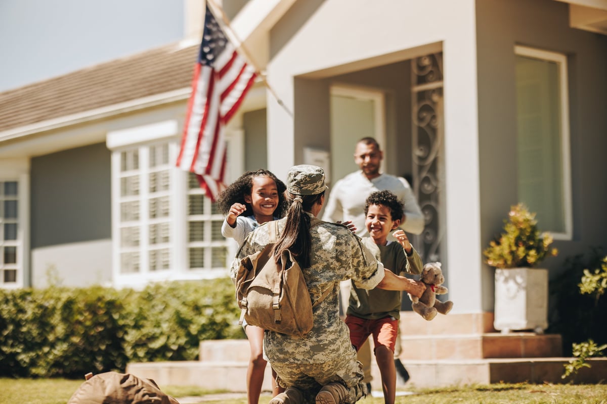 Servicewoman embracing her children after arriving home from the army